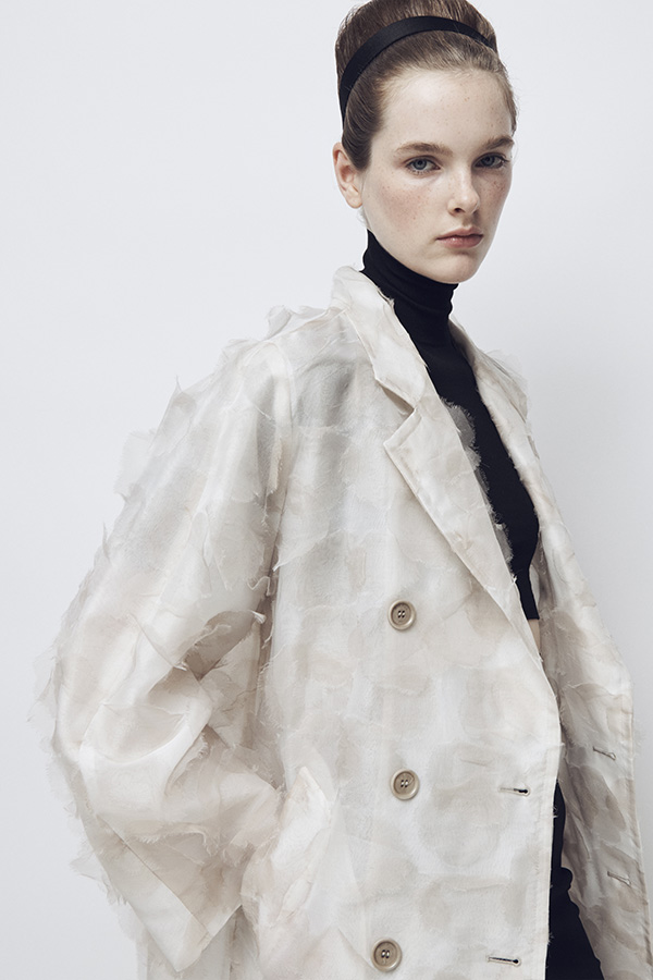Max Mara Spring/Summer 2026 Fashion Show - Model with White Trench Coat look and black turtleneck.